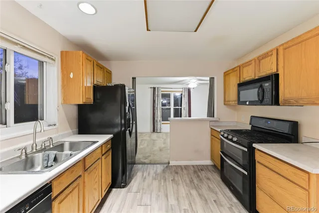 a kitchen with granite countertop a refrigerator stove top oven and sink