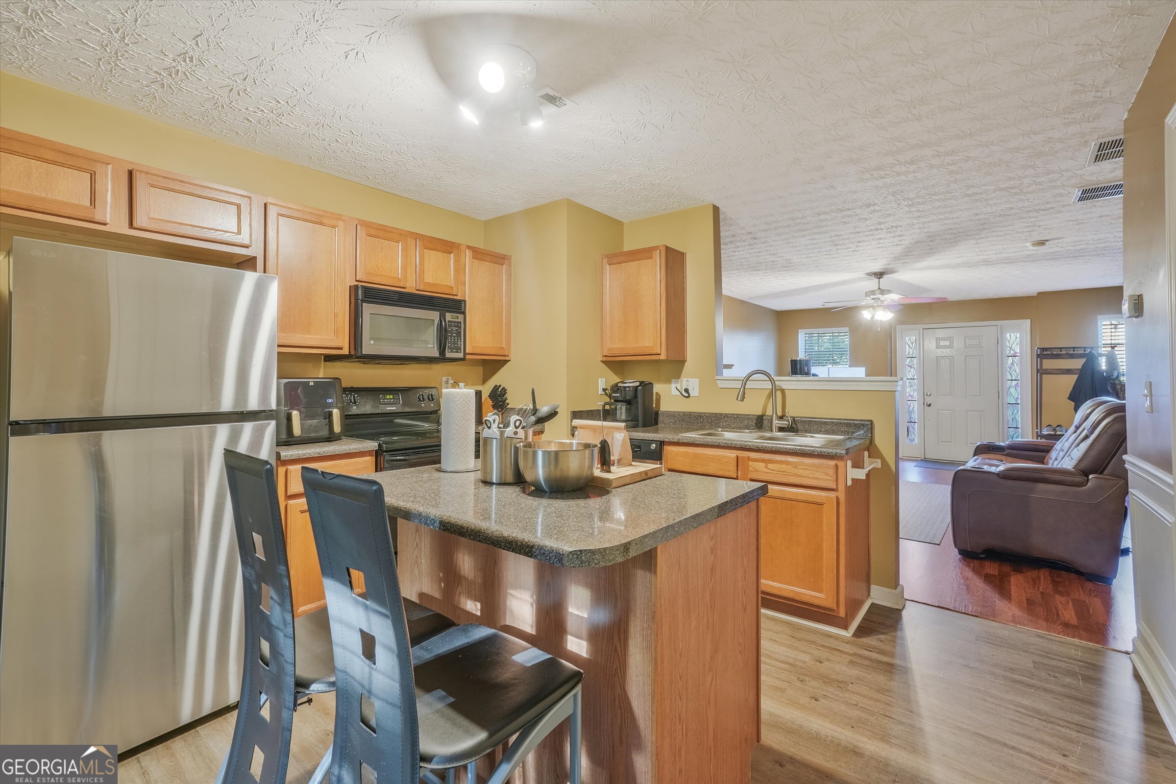 2870 Vining Ridge Terrace Decatur, GA 30034 - Photo 12 of 34 a kitchen with stainless steel appliances granite countertop a refrigerator a sink dishwasher a stove and a dining table with wooden floor