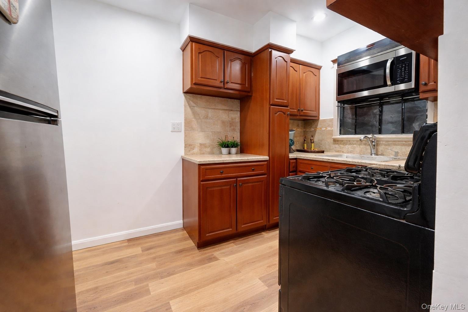 219-42 141st Road Queens, NY 11413 - Photo 8 of 23 a kitchen with a stove and a microwave