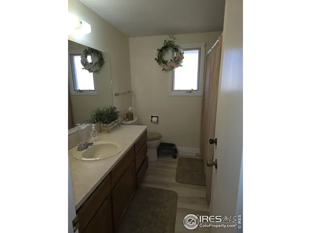 a bathroom with a granite countertop sink a toilet and shower