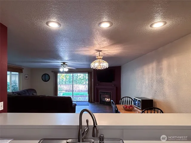 a living room with furniture a fireplace and a large window