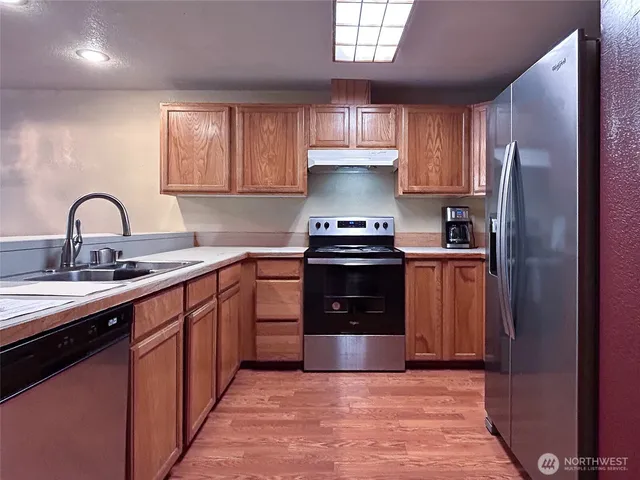 a kitchen with stainless steel appliances granite countertop a sink stove and refrigerator