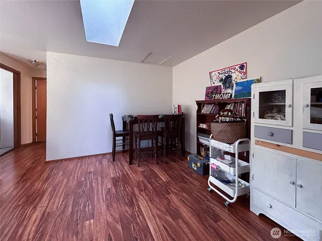 a view of a workspace with furniture and wooden floor