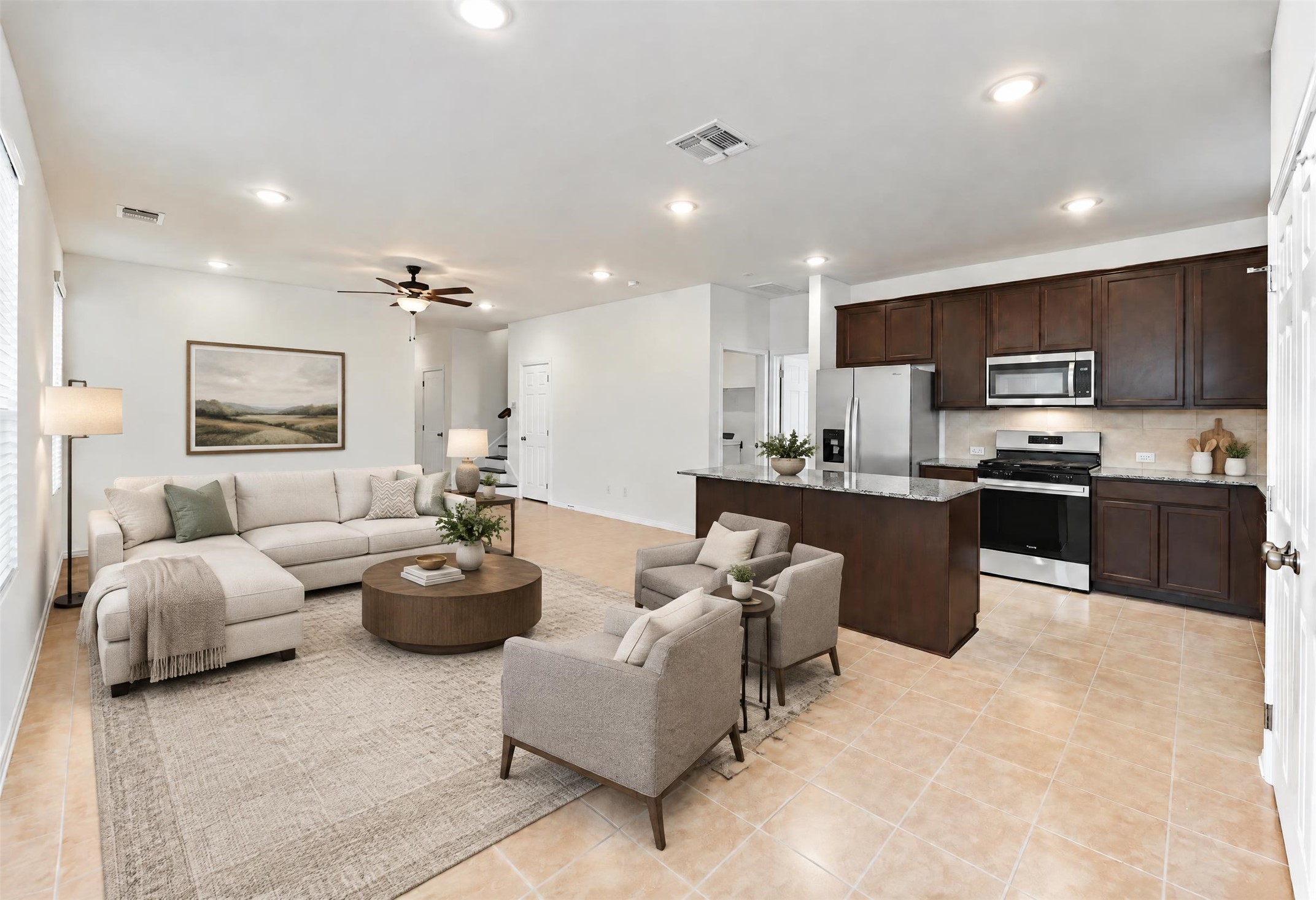 545 Henry Milton Road Georgetown, TX 78626 - Photo 3 of 33 Recessed lighting and tile floors highlight this airy open-concept living area and kitchen layout.