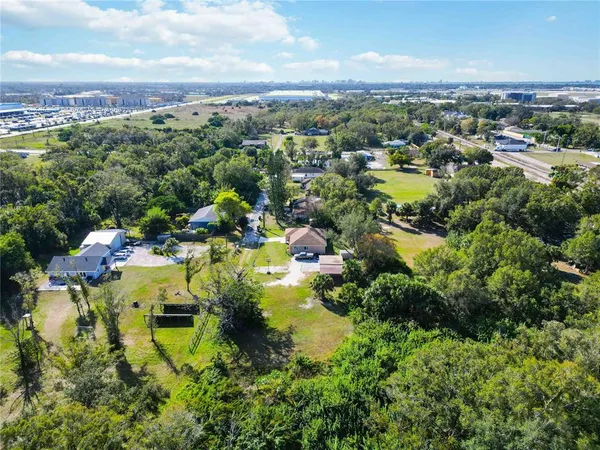 an aerial view of residential houses with outdoor space and trees