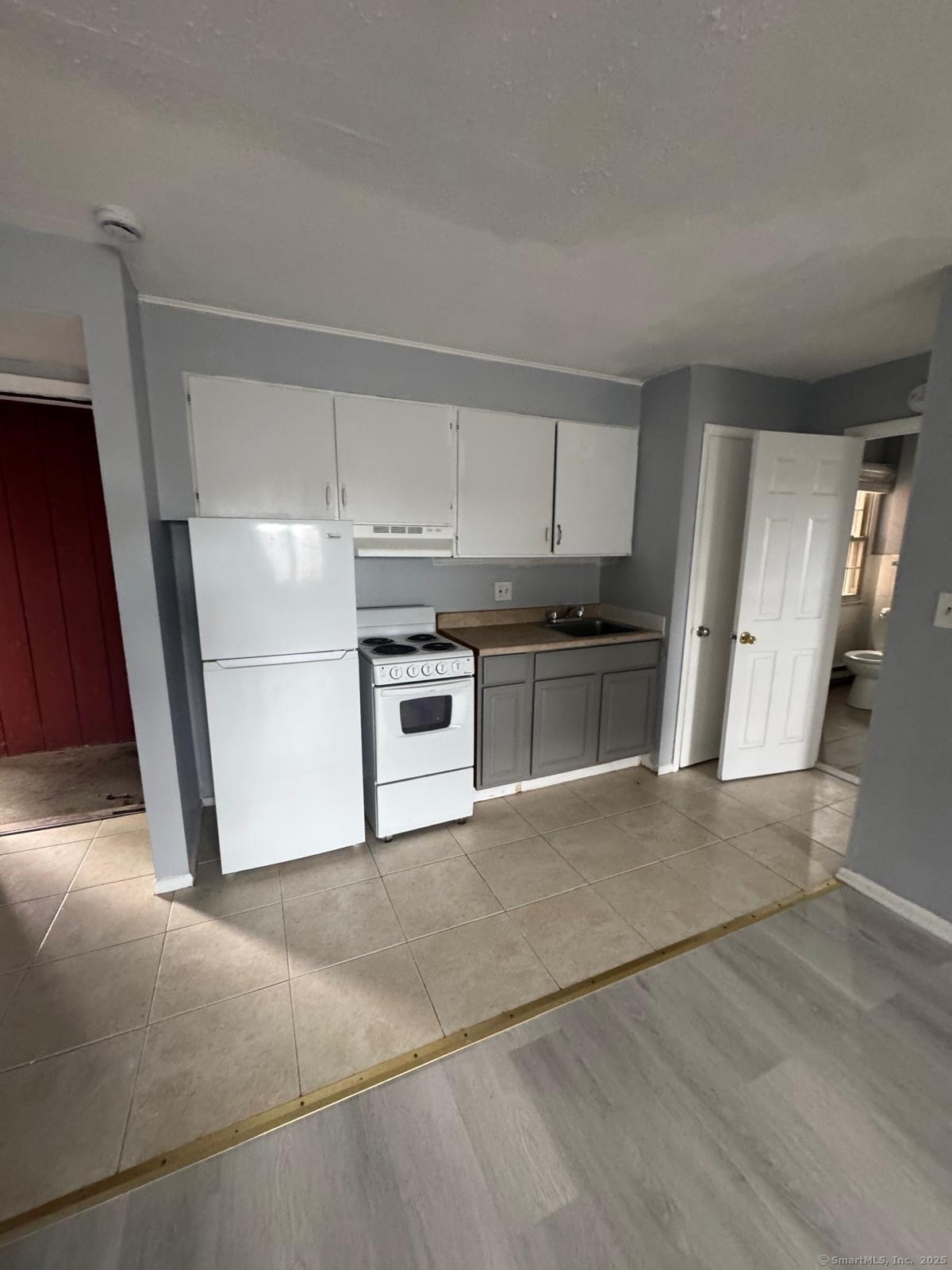 a kitchen with a stove a refrigerator and a sink