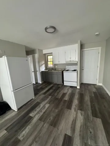 a kitchen with a refrigerator and white cabinets