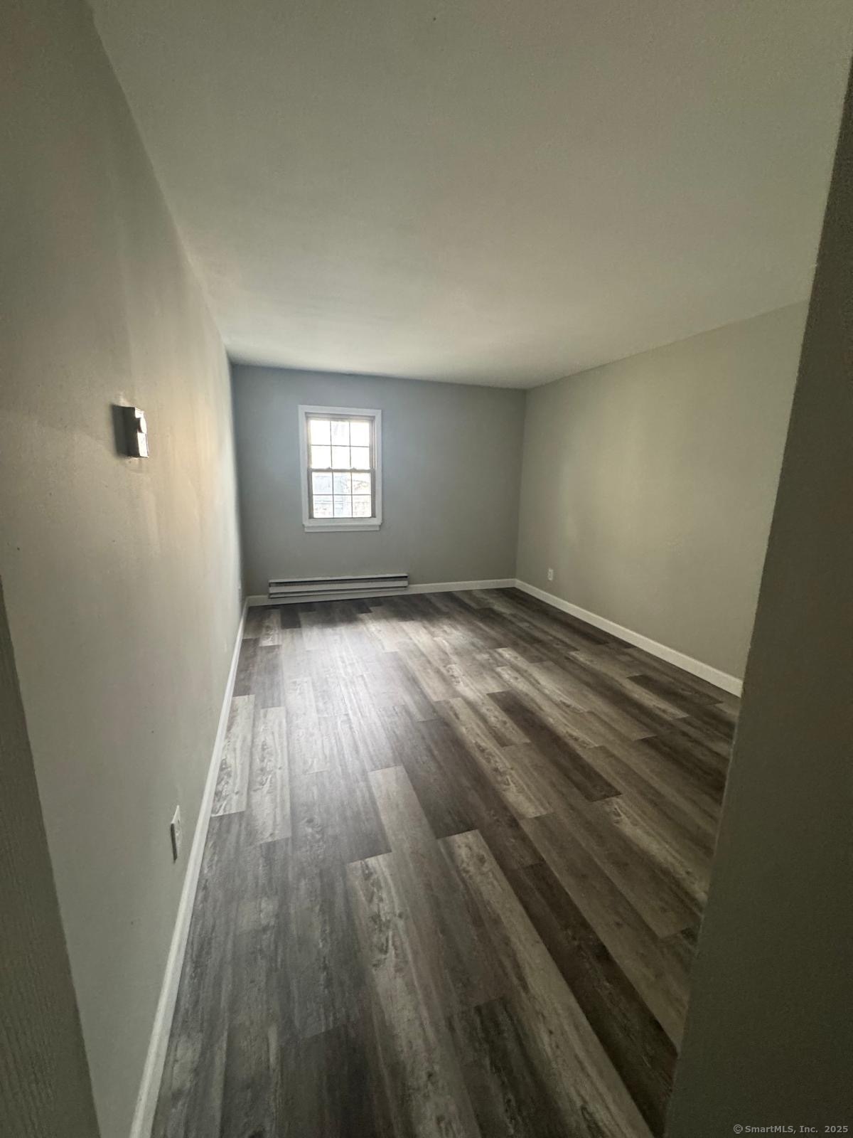 240 Oak Street, Unit 7 Bridgeport, CT 06604 - Photo 3 of 6 an empty room with wooden floor and windows