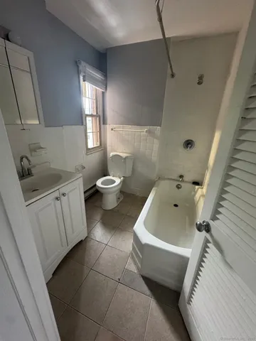 a bath room with a toilet sink and bath tub