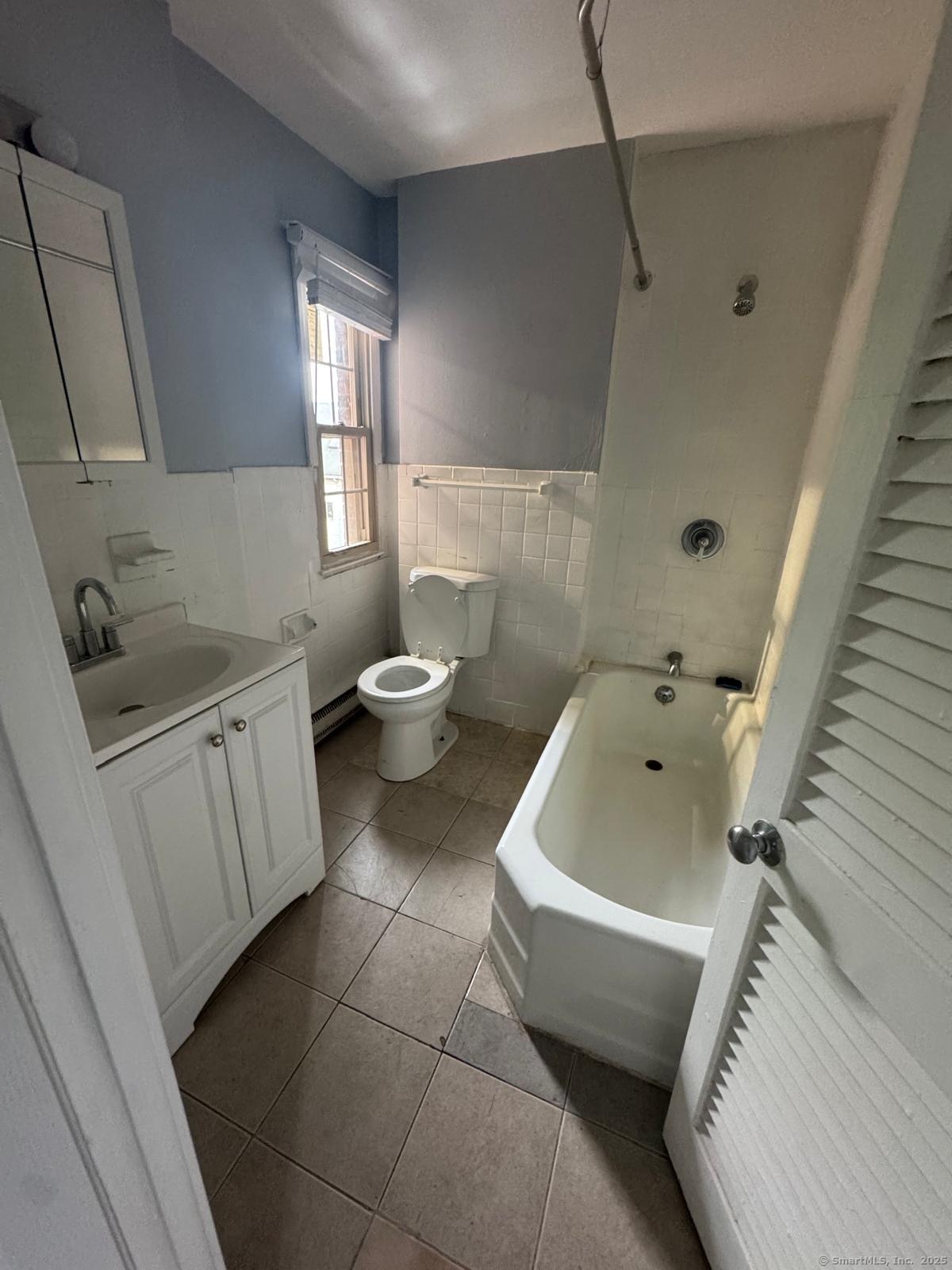 240 Oak Street, Unit 7 Bridgeport, CT 06604 - Photo 5 of 6 a bath room with a toilet sink and bath tub