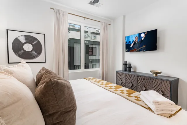 a bedroom with a bed and flat screen tv