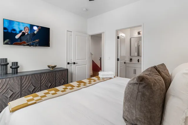 a bedroom with a bed and a flat screen tv