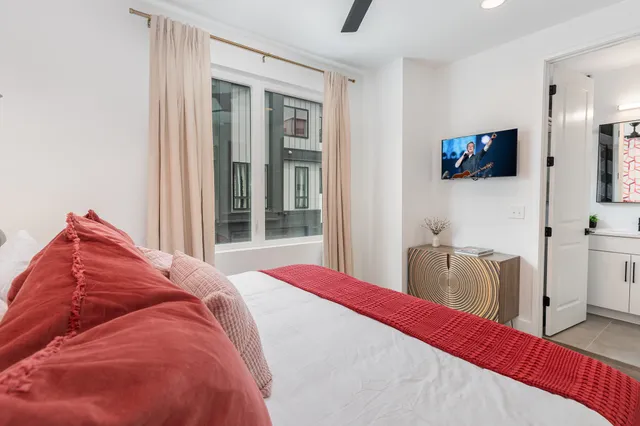 a bed sitting in a bedroom and a flat screen tv