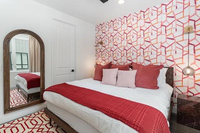 a bedroom with a large bed and a lamp