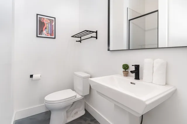 a bathroom with a toilet a sink and mirror