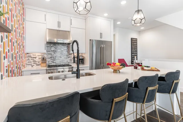 a kitchen with stainless steel appliances kitchen island granite countertop a sink and a refrigerator