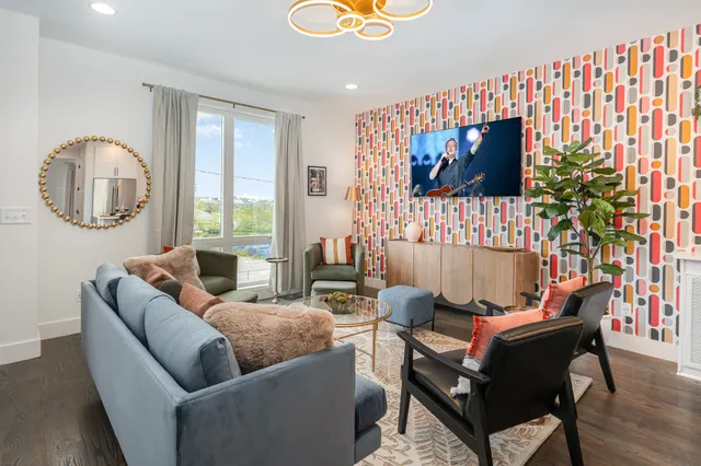a living room with furniture and a floor to ceiling window