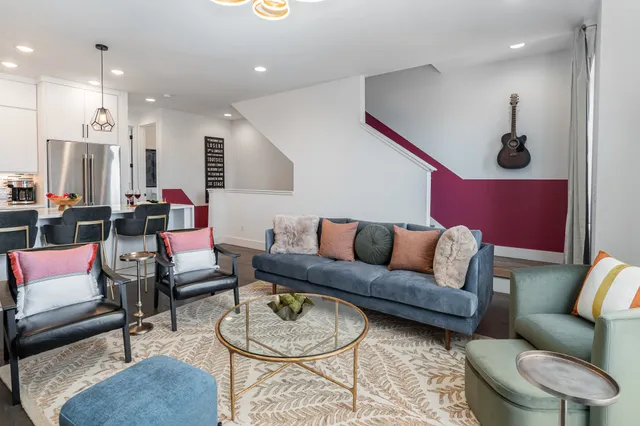 a living room with furniture a rug and kitchen view
