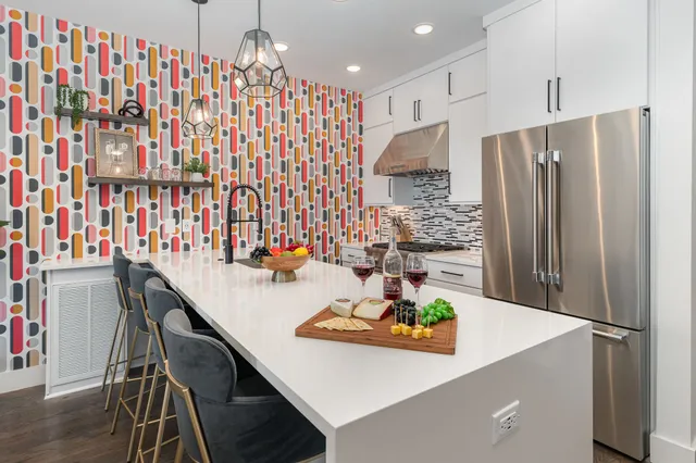 a kitchen with stainless steel appliances a dining table chairs and a refrigerator
