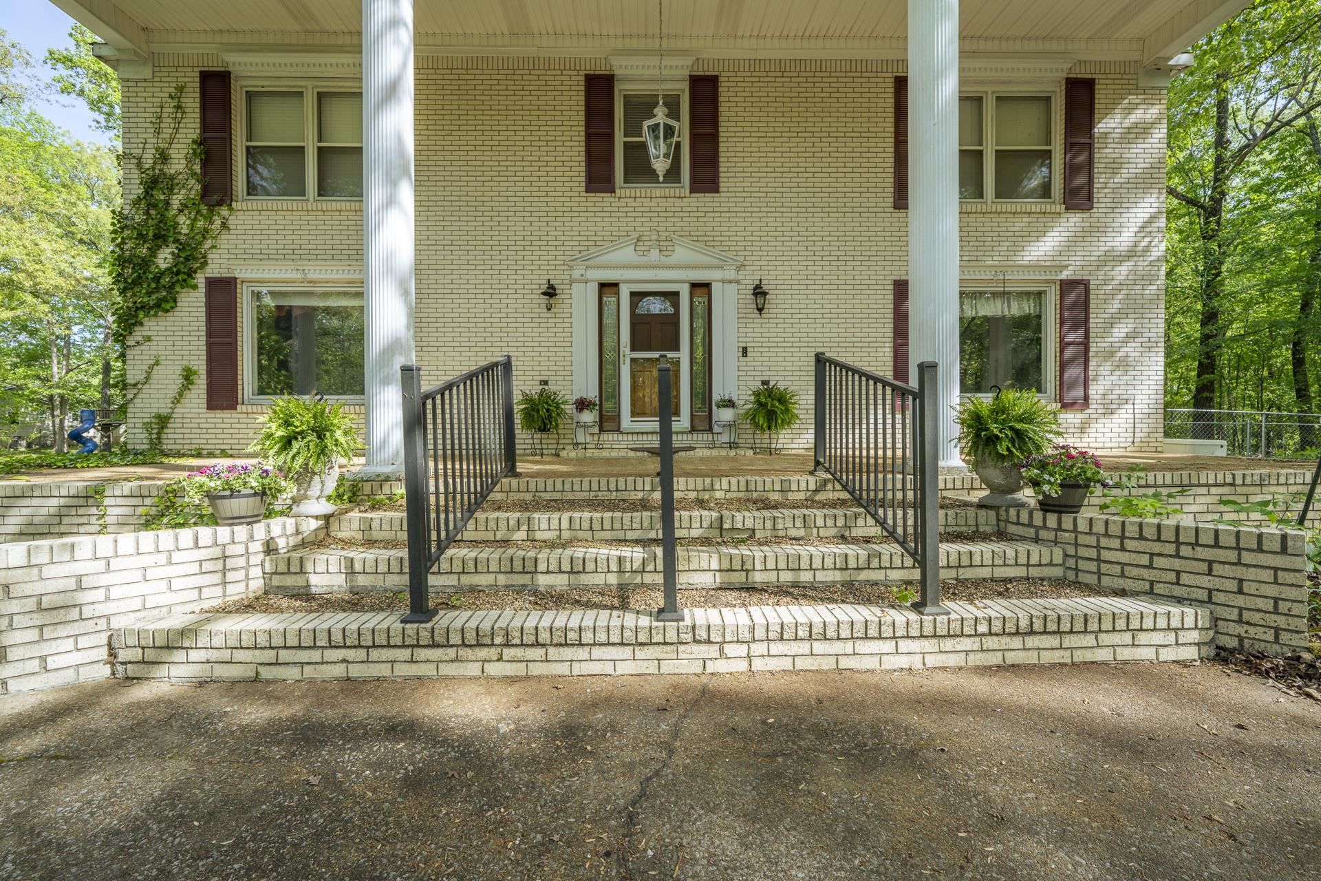 101 Bob Street Selmer, TN 38375 - Photo 2 of 40 front view of a brick house with a fountain