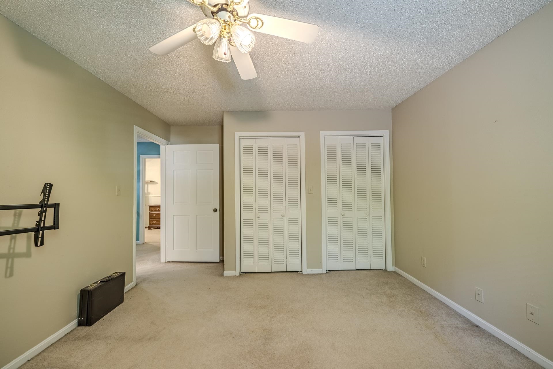 101 Bob Street Selmer, TN 38375 - Photo 23 of 40 an empty room with a chandelier fan and windows