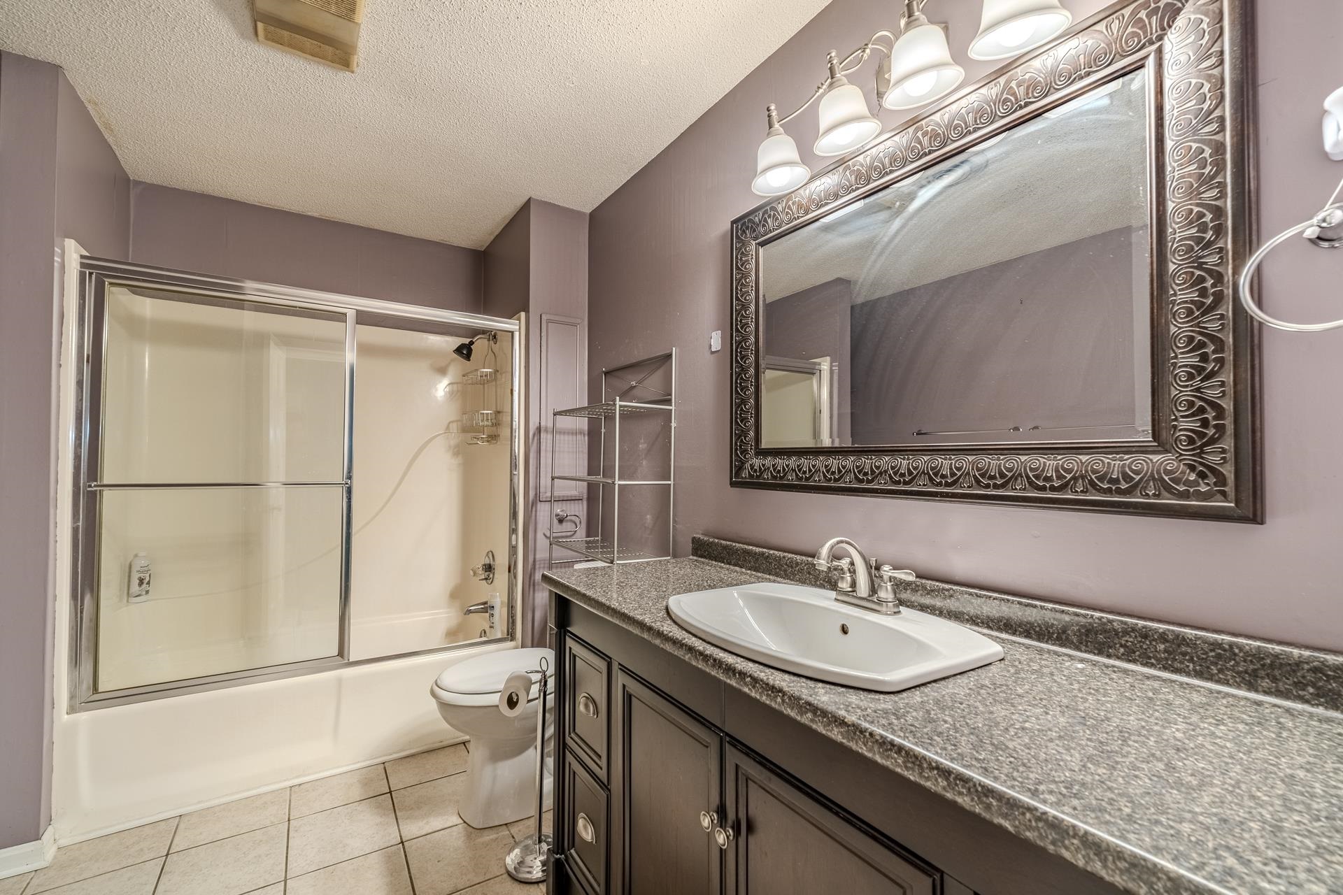 101 Bob Street Selmer, TN 38375 - Photo 25 of 40 a bathroom with a granite countertop sink a mirror a vanity and a shower