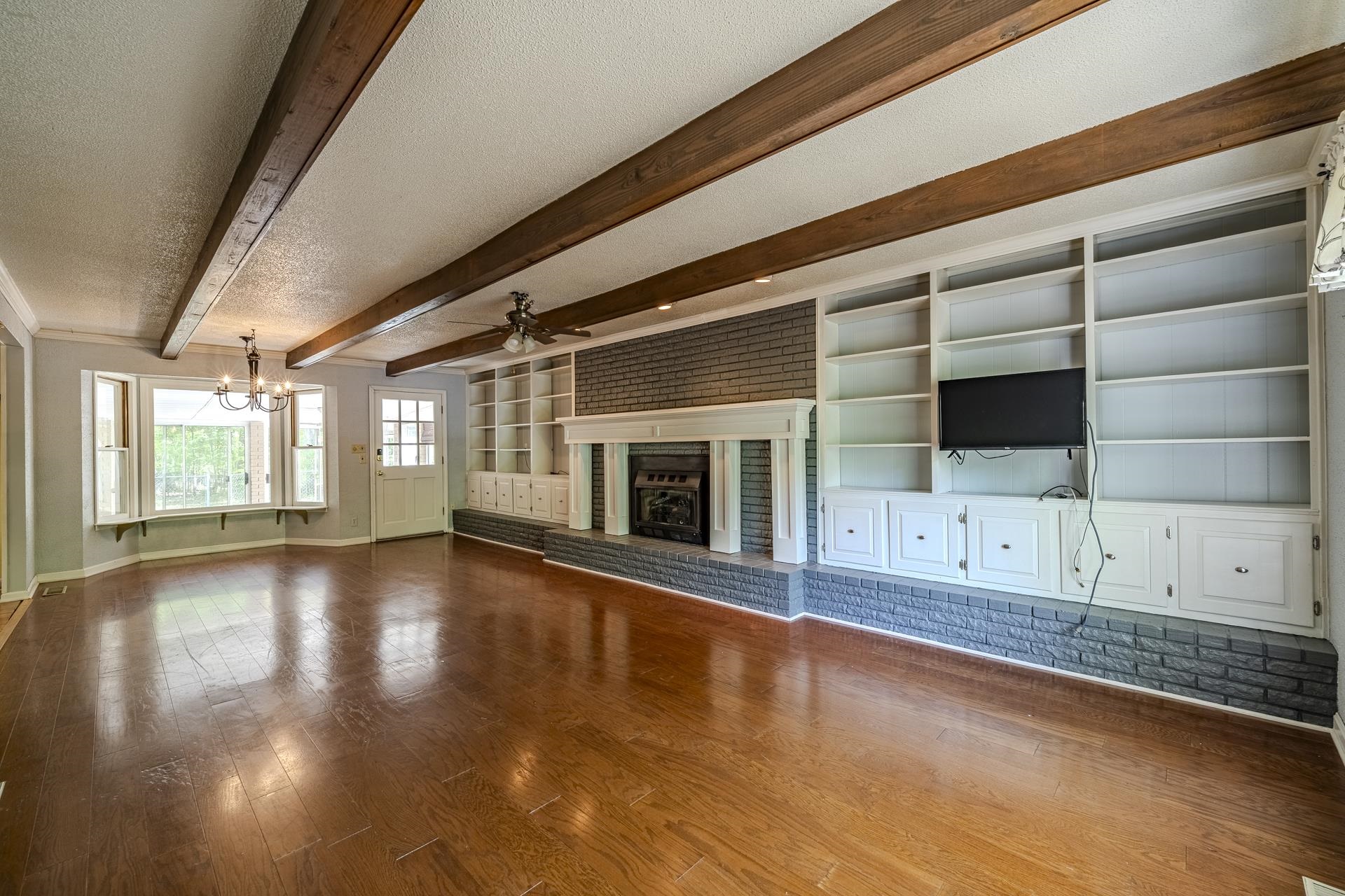 101 Bob Street Selmer, TN 38375 - Photo 6 of 40 a view of an empty room with a fireplace and wooden floor