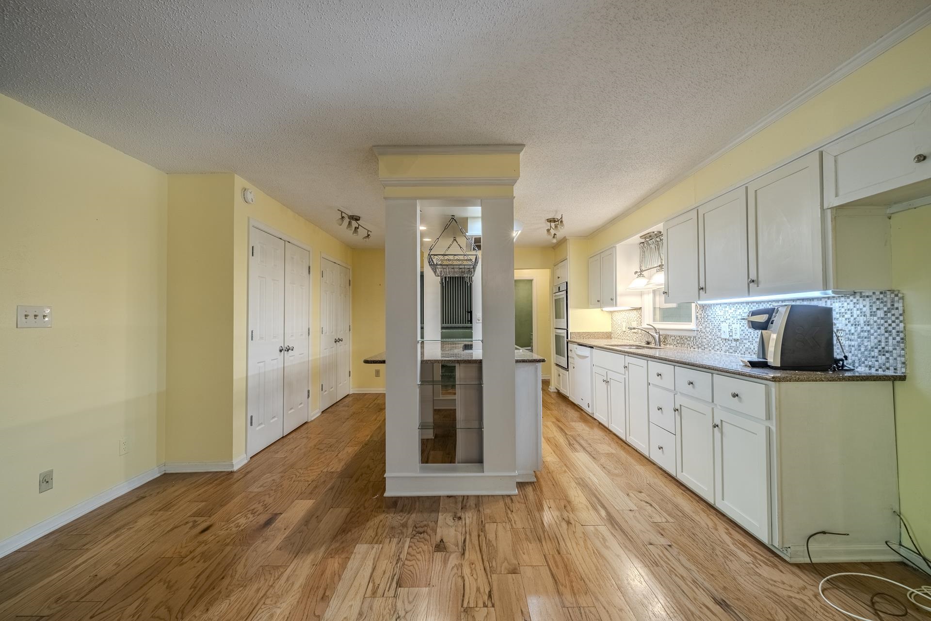 101 Bob Street Selmer, TN 38375 - Photo 10 of 40 a kitchen with granite countertop a refrigerator a sink and wooden floors