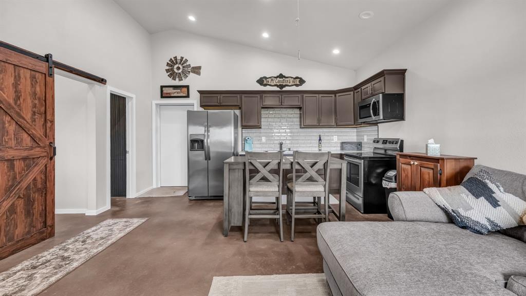 3810 Fairview Road Millsap, TX 76066 - Photo 12 of 25 a living room with furniture a flat screen tv and kitchen view