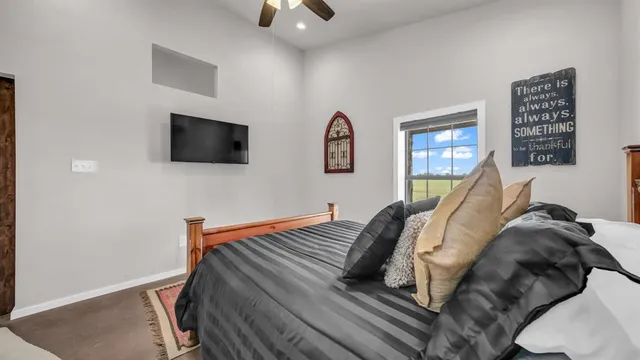 a view of a bedroom with furniture and a flat screen tv