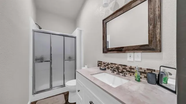 a bathroom with a double vanity sink mirror and shower