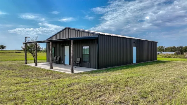 a backyard of a house with table and chairs