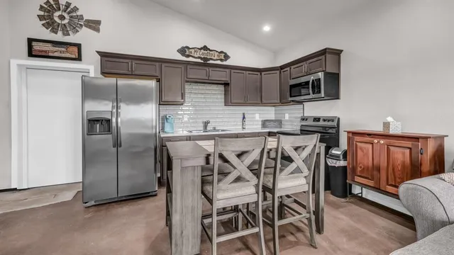 a kitchen with stainless steel appliances kitchen island granite countertop a refrigerator and microwave