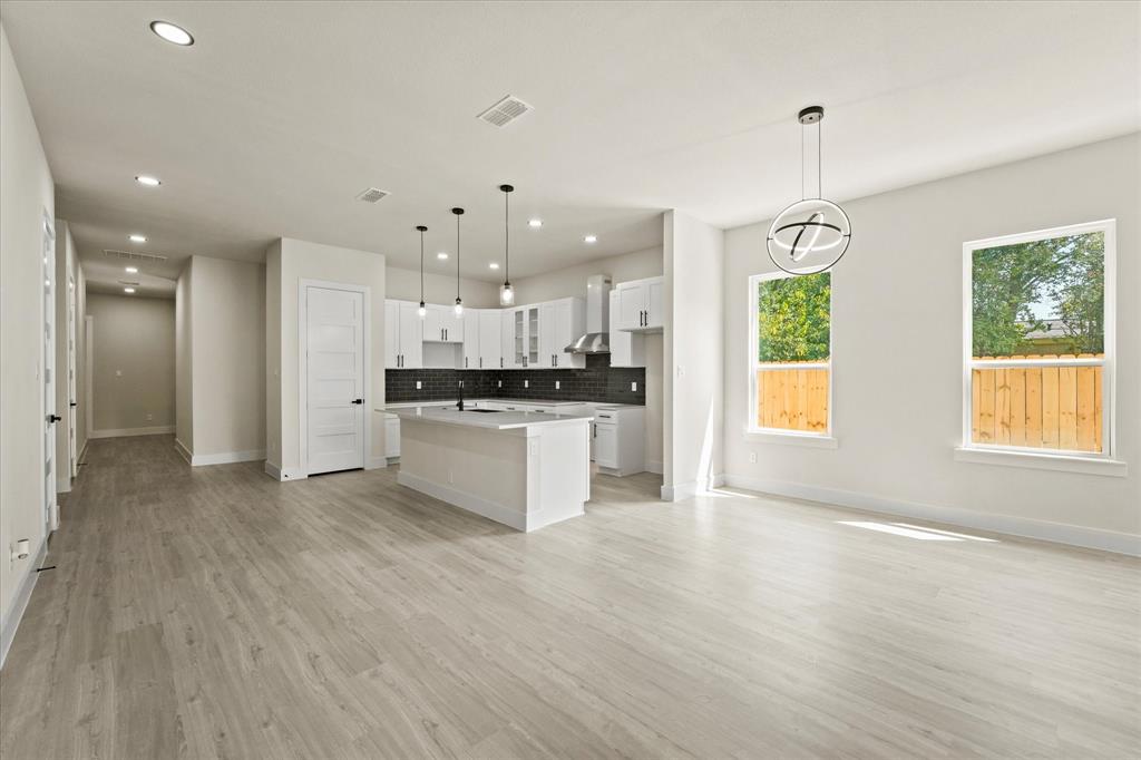 4020 Ranger Drive Dallas, TX 75212 - Photo 6 of 28 a large kitchen with stainless steel appliances kitchen island a large counter top and a wooden floors