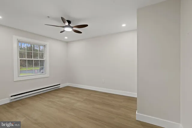 an empty room with a window and ceiling fan