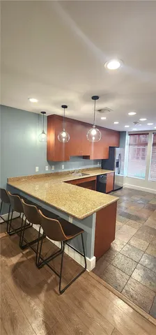 a room with stainless steel appliances lots of wooden furniture