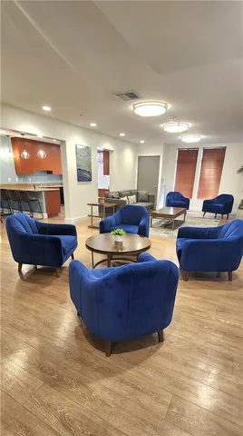 a living room with stainless steel appliances granite countertop furniture and a wooden floor