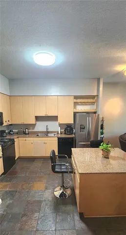 a living room with granite countertop furniture and kitchen view