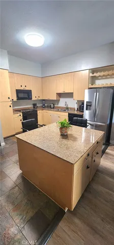 a kitchen with stainless steel appliances granite countertop a lot of counter space and wooden floor