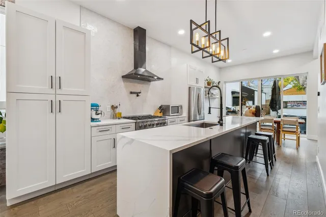 a kitchen with stainless steel appliances a table chairs and chandelier
