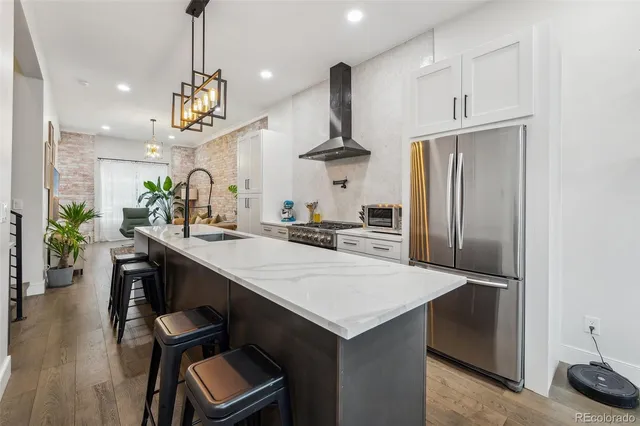 a kitchen with stainless steel appliances a table chairs refrigerator and microwave