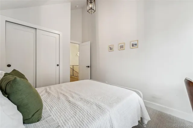 a bedroom with a bed and a painting on the wall