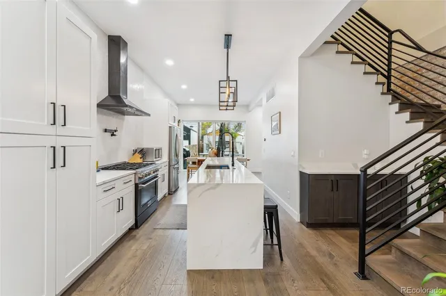 a kitchen with stainless steel appliances granite countertop a sink a stove and refrigerator