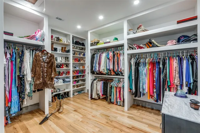 a view of walk in closet with clothes and shoes