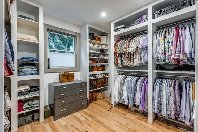 a view of walk in closet with clothes and shoes