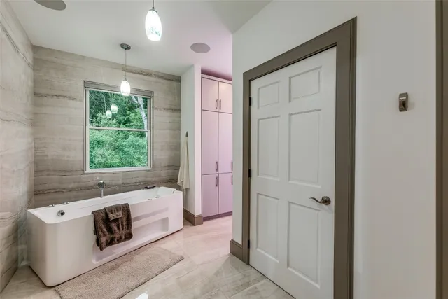 a bathroom with a bathtub sink and window