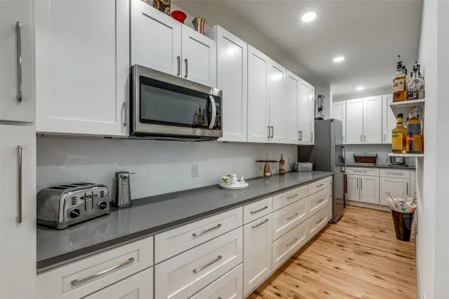a kitchen with granite countertop white cabinets stainless steel appliances and sink