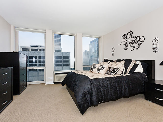 111 East Chestnut Street, Unit 16F Chicago, IL 60611 - Photo 12 of 20 a bedroom with a bed and a television