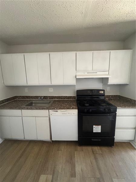 3288 Covington Drive Decatur, GA 30032 - Photo 6 of 15 a kitchen with granite countertop a stove and a white cabinets