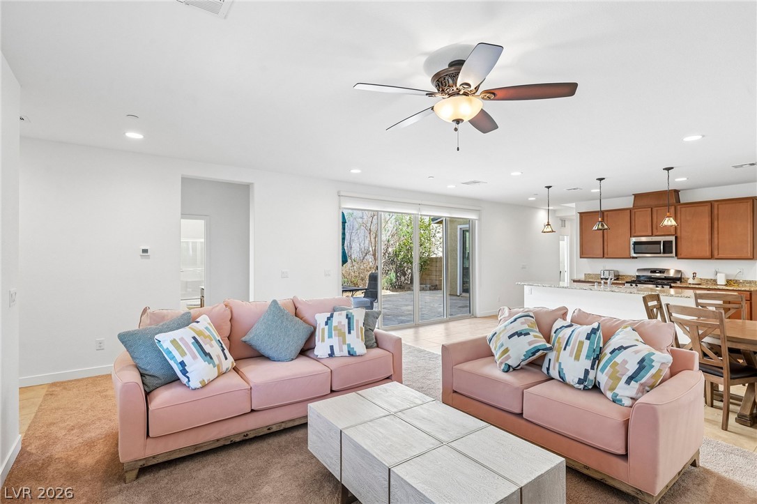 An open-concept living area connects seamlessly with the kitchen and features sliding glass doors.
